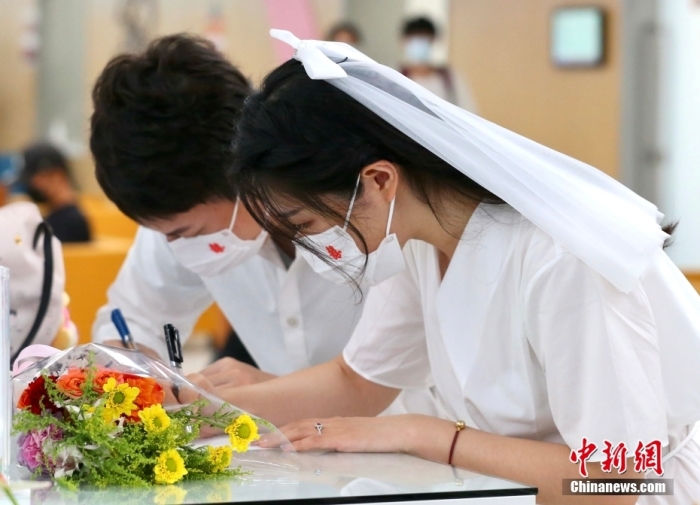 資料圖：一對(duì)新人正在辦理結(jié)婚登記。 <a target=